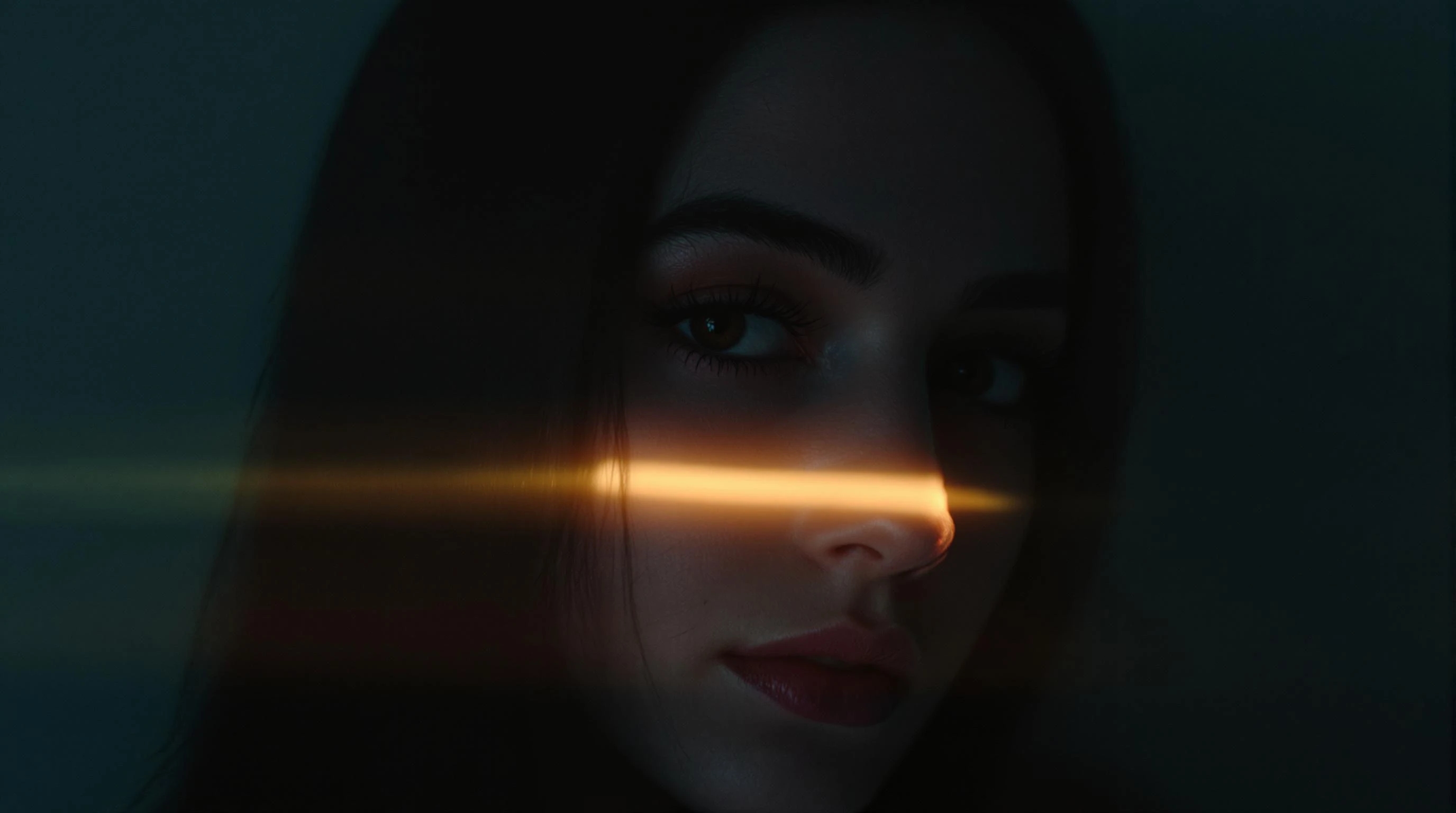 A mysterious portrait of a woman's face, partially obscured by darkness, with a golden light streak crossing her eyes.