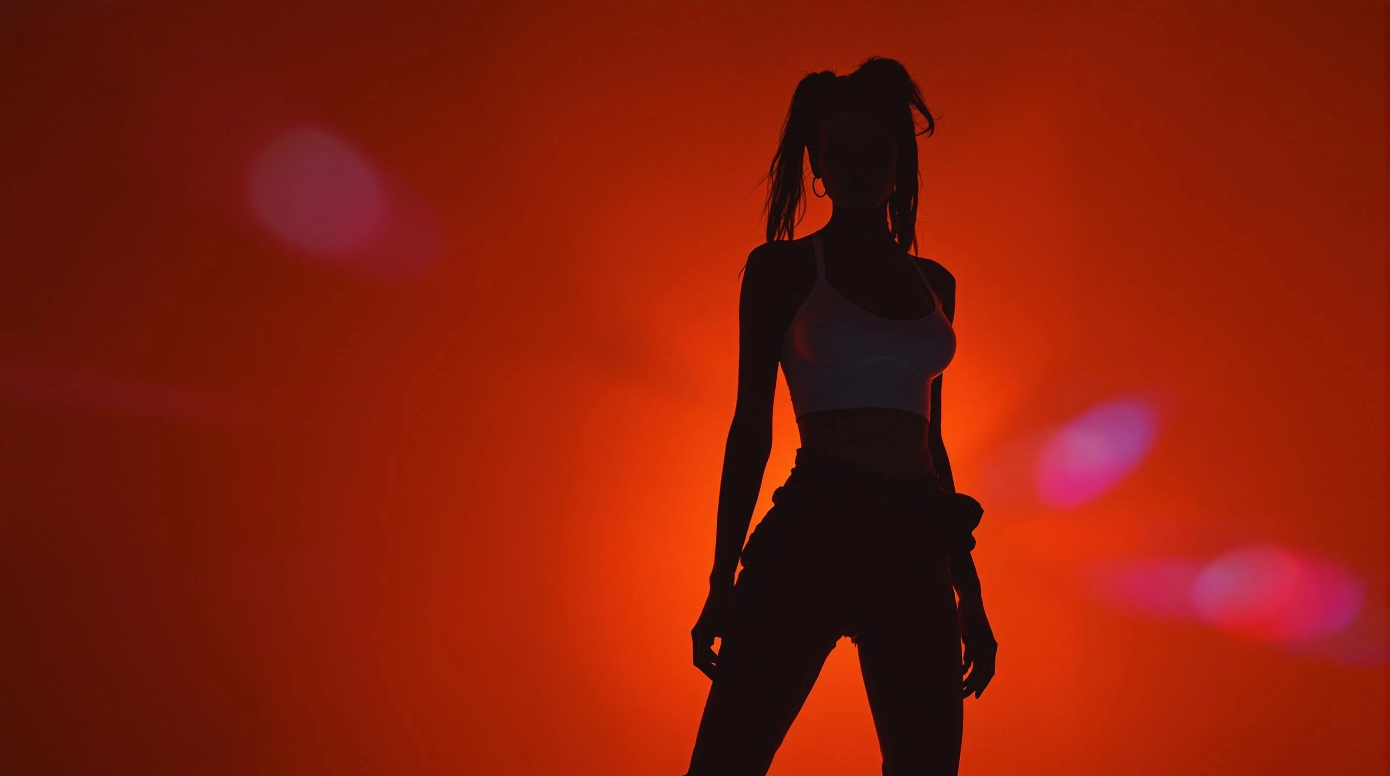 A striking silhouette of a woman in athletic wear, standing confidently against a glowing red-orange background